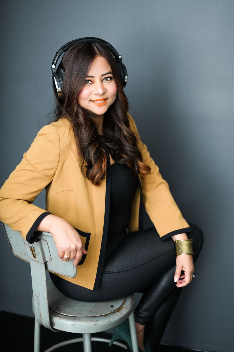 Yamini Ranjan, host of Women of Wayland, wearing headphones